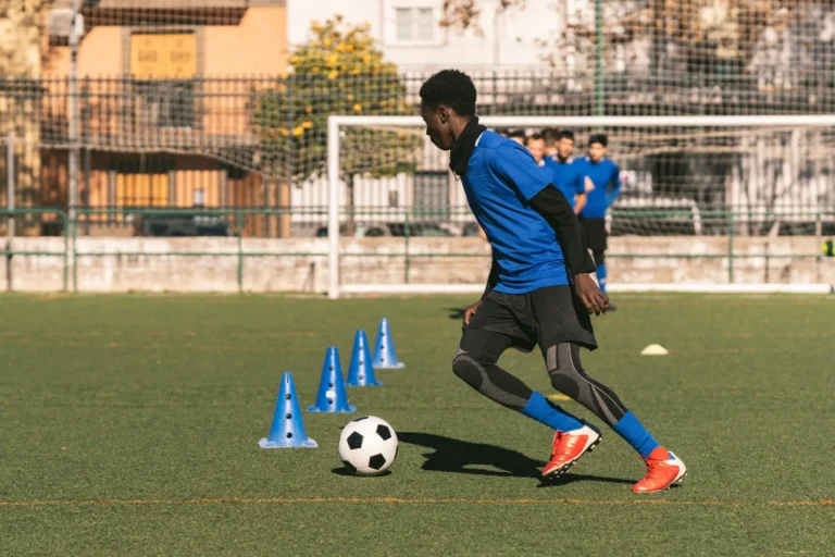 Young soccer player dribbling through cones on an outdoor field