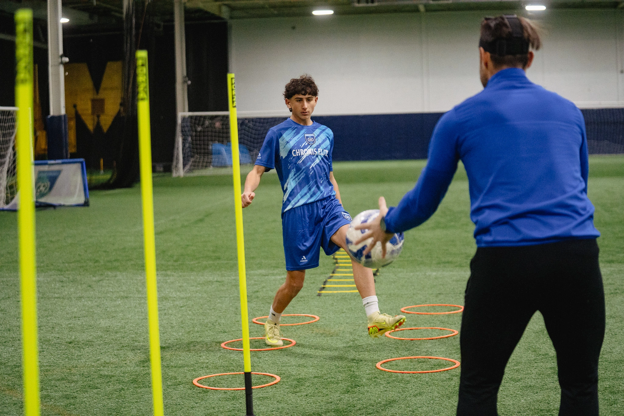 Chronis Elite coach working one-on-one with a youth soccer player on ball control and footwork indoors