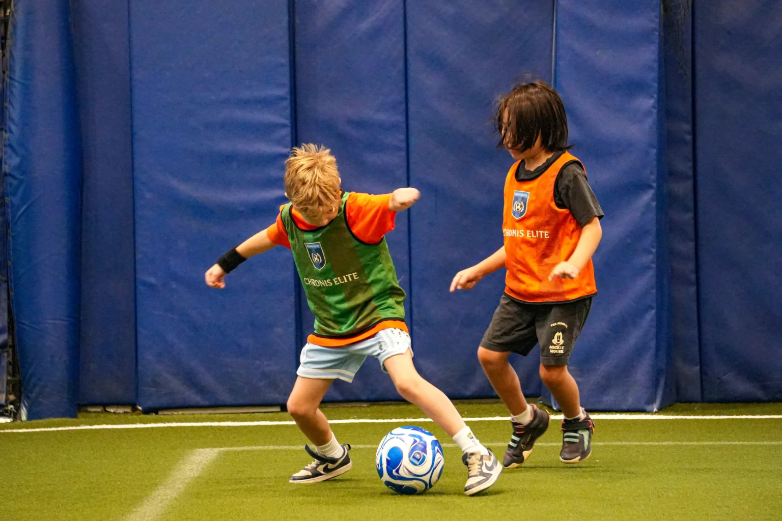 Soccer classes for kids: a young player practicing ball control during an indoor Chronis Juniors session